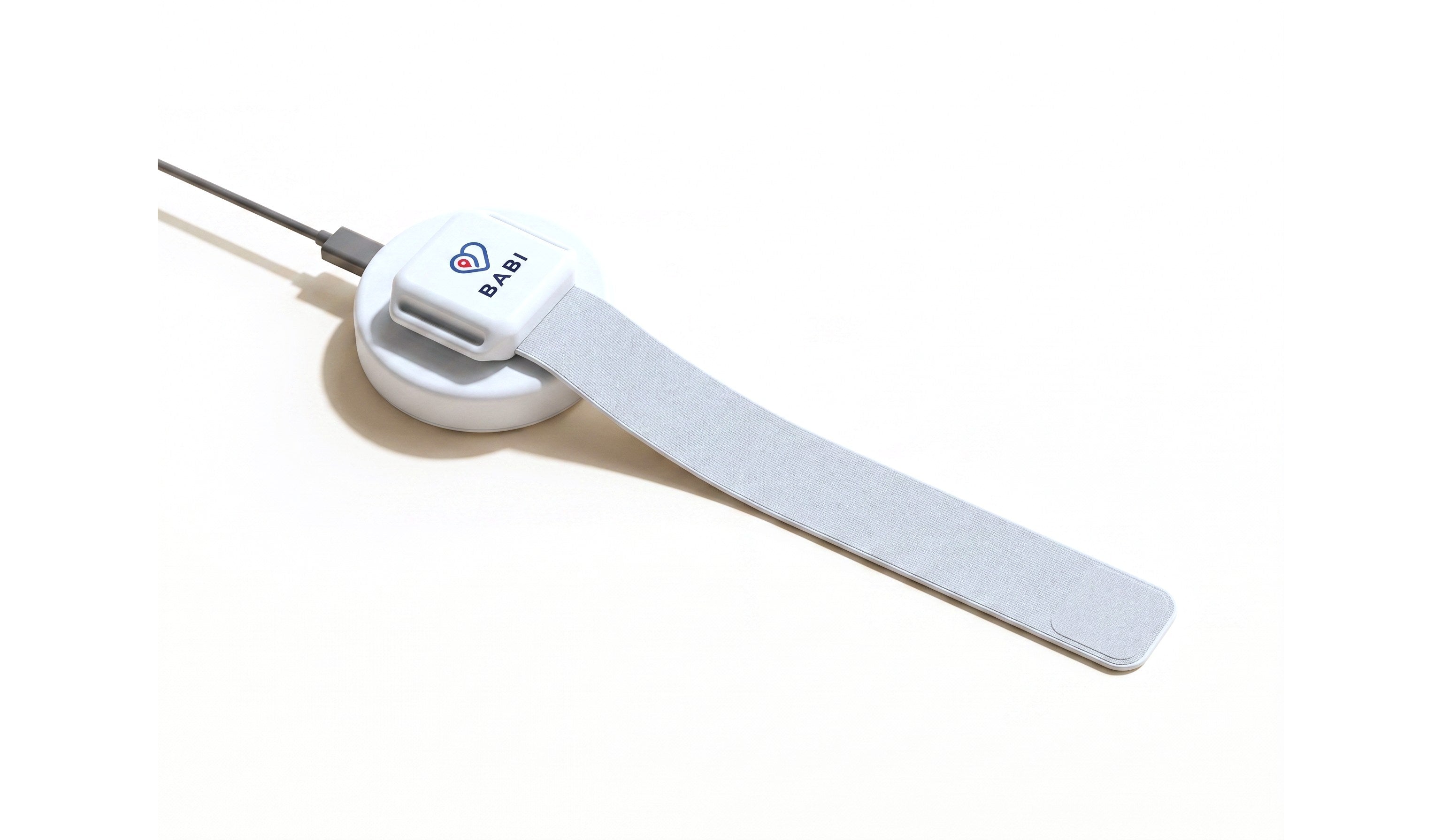 Babi Angel™ band on its charging cradle