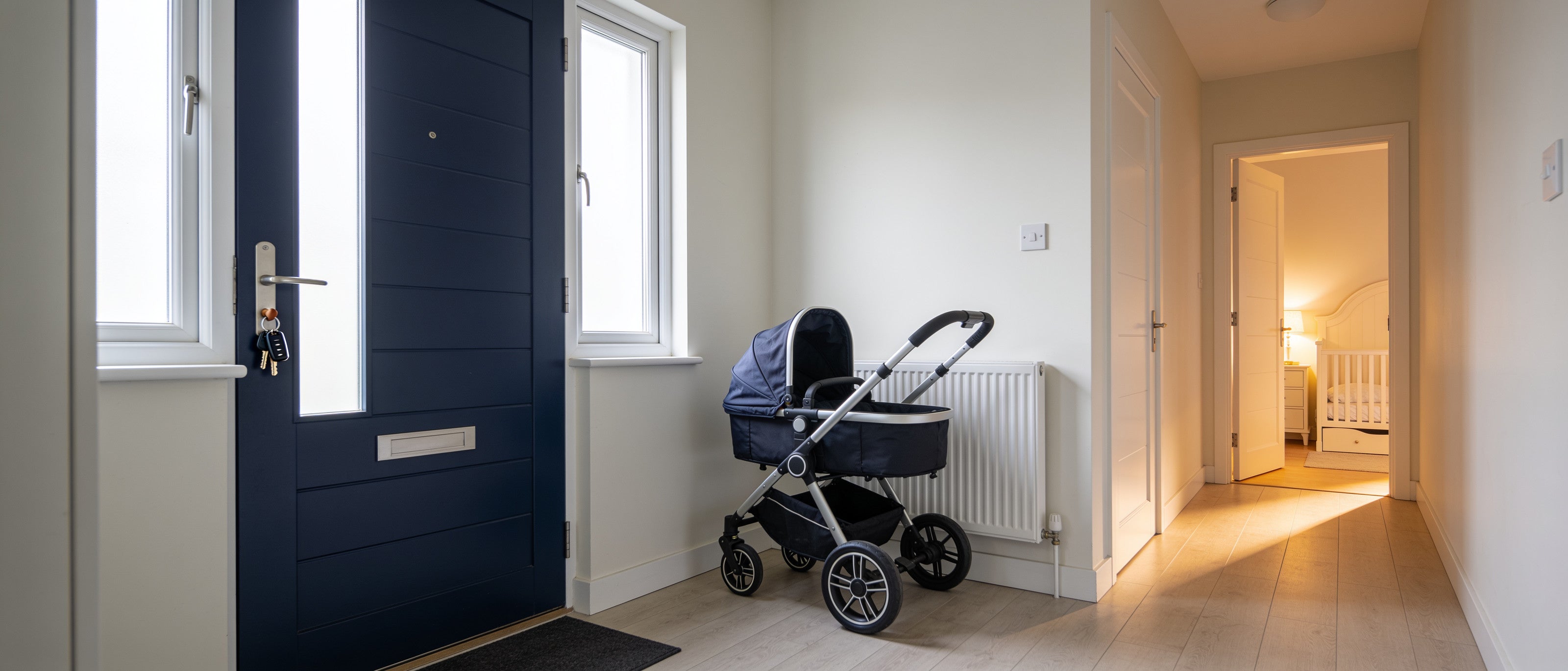 A family hallway at first light: the front door and a nursery door ajar
